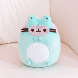 Full view of the Pusheen Frog Plush.  Pusheen’s paws can be seen in this view where her top paws come together like she’s clapping whil the bottom paws sit right below the white embroidery detail on the detail of the plush.  