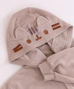 Close up of the embroidery of Pusheen's face on the classic kigurumi hood. The hood also features cat ears made of the same material as the kigurumi, and brown felt whiskers. Under the hood is the hem of the sleeve that has a stretchy ribbed cuff. 