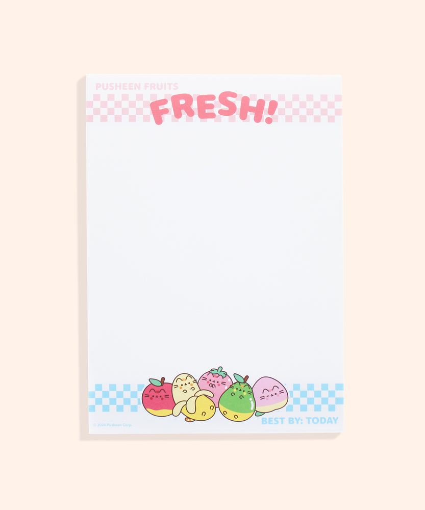 Front view of the white, rectangular Fruits notepad. At the top is a light pink checkered print with the phrases "Pusheen Fruits" and "Fresh!" At the bottom is a light blue checkered print with the phrase "Best by: Today" in light blue as well. In the center of the bottom border print are graphics of Pusheen as various fruits including a red apple, a partially peeled banana, a clapping pink strawberry, a relaxed green pear, and a winking pink and yellow peach.