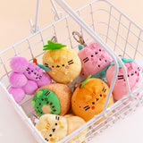 Pusheen Fruits Surprise Plush sits inside a white metal basket. The colorful fruits include purple, yellow, green, brown, orange, and pink. 