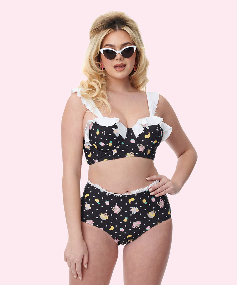 Model wears the Pusheen Tropical Fruit Bikini Set. The black swimsuit features an all over print of Pusheen and Stormy in pool floaties surrounded by white polka dots and tropical fruits.