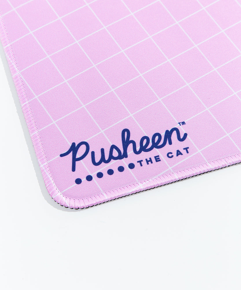 Close up of the Pusheen the Cat Logo on the lower left side of the Gaming Desk Mat. The edges of the mat are sewn, and the rubber base is partially visible.
