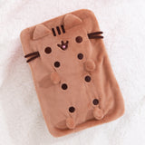 Top view of the squisheen plush shows off Pusheen’s brown face and four paws. Pusheen plush lies on a white surface.  