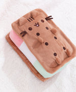 Side aerial view of the Ice Cream plush. In this view, the inner strawberry, vanilla, and pistachio ice creams are shown. On top of the Squisheen, Pusheen’s brown whiskers extend off her rectangular body.  