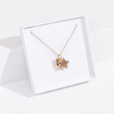 Quarter view of gold vermeil finish of the Pusheen Celestial Charm Necklace in its white packaging box. 