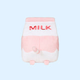 The back view of the Juice Box Sips Plush shows off pink ‘Milk’ embroidery, pink feet, and white and pink striped tail that extends slightly off the body of the carton-shaped plush. 