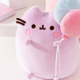 Close-up view of the Pusheen Anniversary Plush. Pusheen's facial features are embroidered on the front top of the sitting pose Squisheen plush.