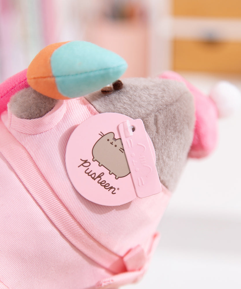 Close-up view of light pink Pusheen logo tag and embossed Pusheen Label tag attached to the side of the Artist Pusheen Plush. 