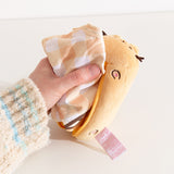 Model pulling yellow and golden brown gingham nylon bag out of a yellow plush container.