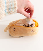 Nylon bag folded into a yellow plush rectangular container.