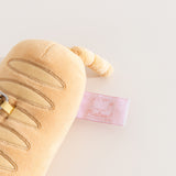 Close-up of the pink Pusheen Shop tag on the side of the Pusheen Baguette Reusable Bag Keychain Plush. 