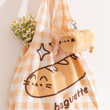 Yellow gingham print bag with a graphic of Pusheen the Cat as a baguette with the phrase "baguette" printed below.
