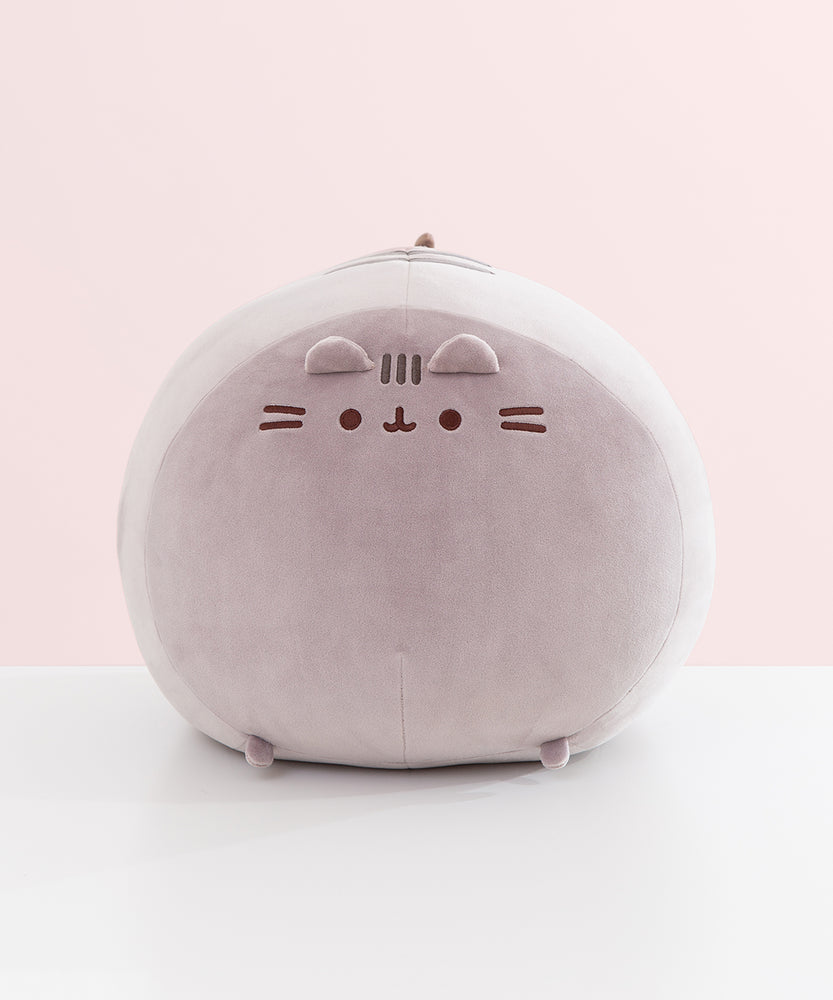 Full view of the front of the extra large squisheen plush of Pusheen. The rounded grey plush has two little paws that extend off the bottom front of the plush.