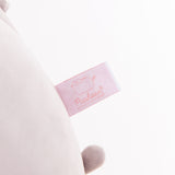 Close-up view of the Pusheen Shop logo tag that is affixed near the bottom of the jumbo grey plush.