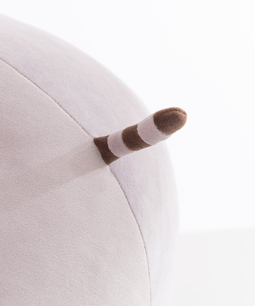 Close-up view of the tail that extends of the back side of the round plush. The tail is brown and gray stiped.