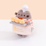 Quarter side view of Baker Plush. Pusheen the Cat wears a checkered top, bowtie, and half apron. 