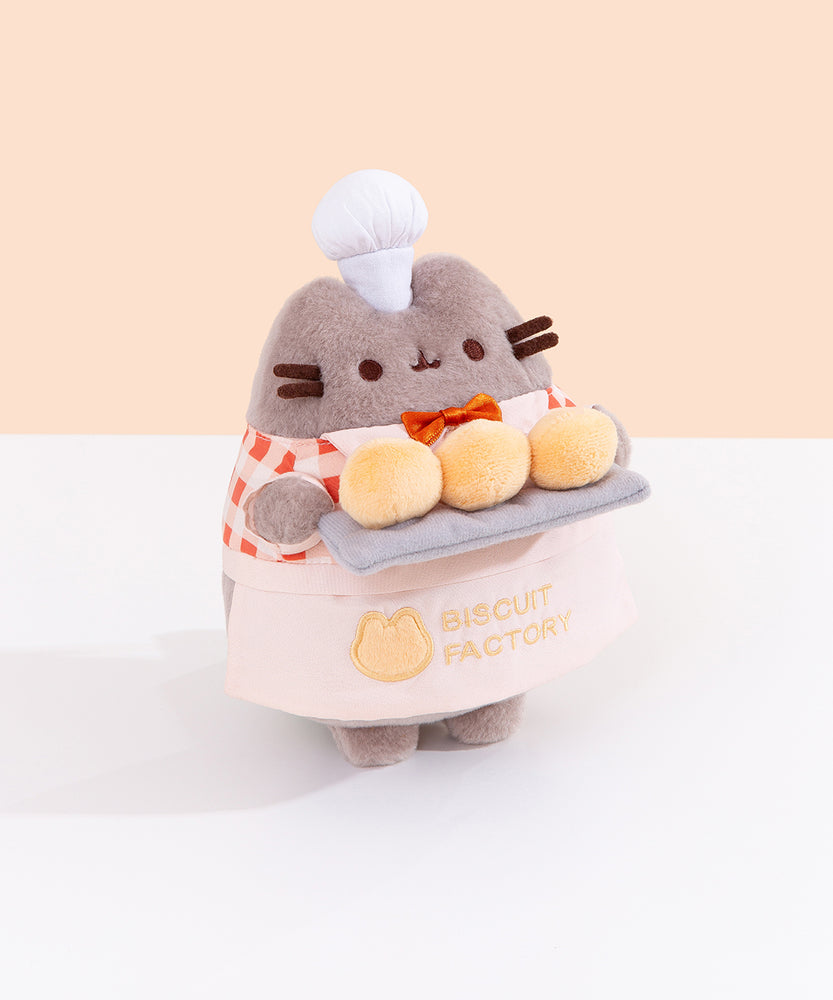 Other side quarter side view of Baker Plush. Pusheen the Cat holds three biscuit buns on a light gray platter. 