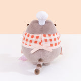 Back view of Baker Pusheen Plush. The checkered top and apron combo are tied in the back with a bow. Pusheen’s gray striped tail is seen coming off the bottom back of the plush. 