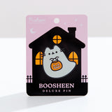 Boosheen Pusheen Deluxe Pin attached to backer card. The ghost shaped pin sits on a white surface and depicts Pusheen the Cat as a friendly ghost while carrying a jack-o'-lantern candy pail. 