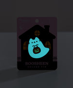 Boosheen Deluxe Pin on backer card. The backing card depicts a haunted-looking black house with orange light peeking through the three windows. The backer card is light purple. 