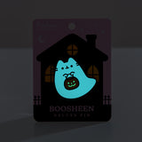 Front view of the glow in the dark element of the Halloween-themed Pusheen pin. The ghost glows light blue while the pumpkin candy pail glow slight green in the dark after being exposed to light.   