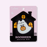 Boosheen Deluxe Pin on backer card. The backing card depicts a haunted-looking black house with orange light peeking through the three windows. The backer card is light purple. 