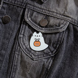 Close-up view of Boosheen-themed pin pinned on a distressed black denim jacket. The ghost-shaped pin is pinned to the front pocket of jacket to show the scale of the pin. 