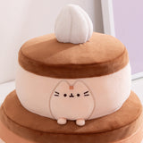 Close-up of the Pusheen figure within the plush cake layers. Pusheen the Cat's two front paws sit outside the top cake layer resting on the bottom layer.