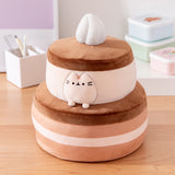 Cake Squisheen shown on a desktop to show scale of 11" tall plush toy. Pusheen the Cat rests inside the top tier of the cake plush.