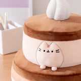 Close-up of the Pusheen plush on the Cake Squisheen. Pusheen's eyes, nose, and whiskers are embroidered in black while her three head stripes are a medium brown embroidery color.