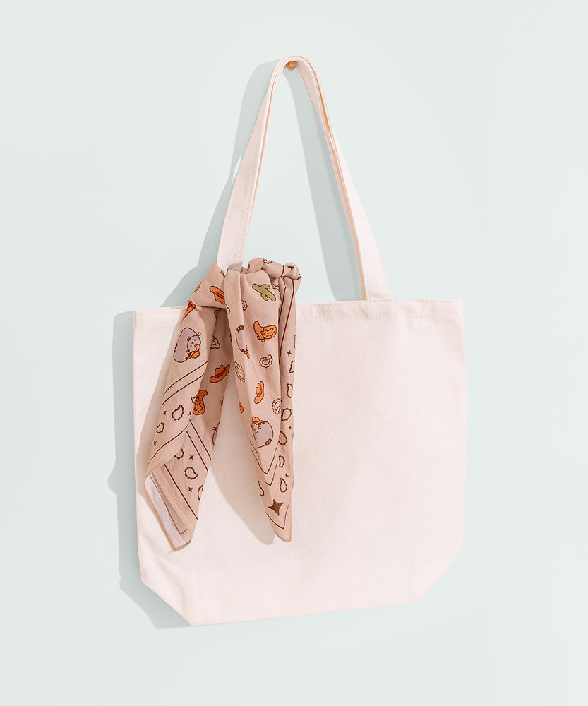 Cowboy scarf tied on handle of white tote bag. The print on the scarf is digitally printed.