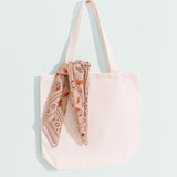 Cowboy scarf tied on handle of white tote bag. The print on the scarf is digitally printed.