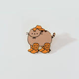 Close-up of Cowboy Pusheen Pin. Pusheen wears a brown cowboy hat and four cowboy boots on her four paws.