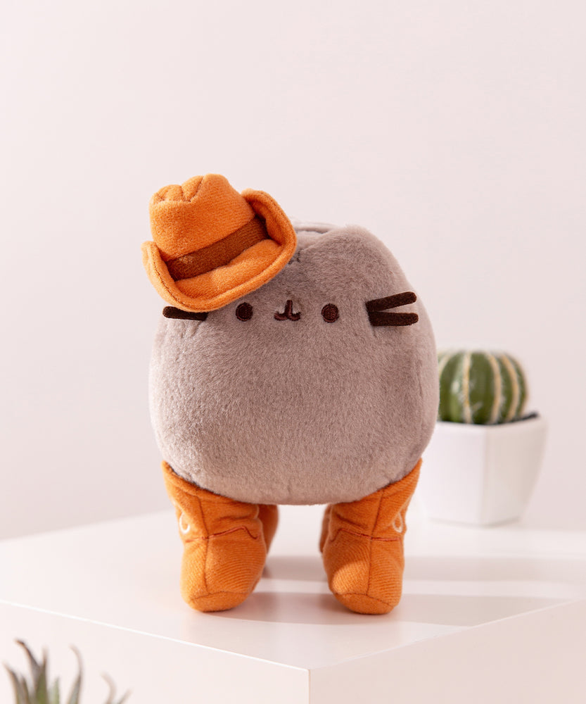 Front view of the fuzzy plush Pusheen. The classic Pusheen has dark brown embroidery for her mouth and eyes as well as dark brown fabric whiskers.