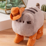 Aerial view of cowboy plush shows Pusheen the Cat's classic two back stripes and striped tail. 