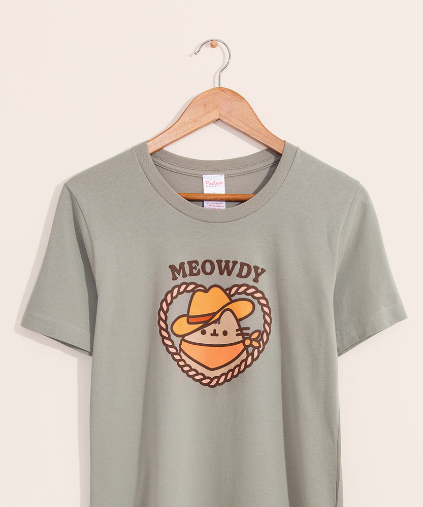 Green t-shirt with a large graphic on the front center. The graphic shows Pusheen the Cat wearing a brown cowboy hat and orange bandana in a heart-shaped rope.