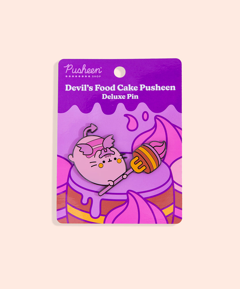 Devil’s Food Cake Pusheen Pin on backer card. The backing card shows many brown, yellow, purple, and pink layered cakes in front of a yellow background. 