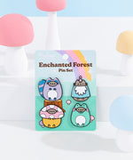 Pusheen Enchanted Forest Pin Set on backing card. The backing card features a forest scene with mushrooms and a wood stump with a purple, pink, and yellow rainbow in the background. 