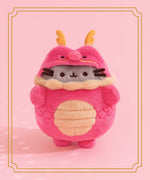 Pusheen Year of the Dragon Plush in front of a light pink background. The red plush is surrounded by a two-striped gold border.