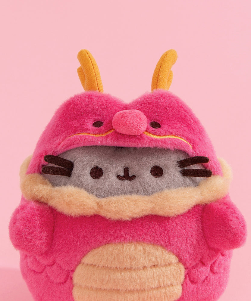 Model holding Lunar New Year Pusheen Dragon Plush to show size scale. The bottom of the plush fits in the models hands while the head and legs are not encompassed by the hands.