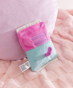 Back view of the bag of chips plush. Pusheen the Cat's striped tail sticks out the back of the blue portion of the bag. The pink top half of the bag features Pusheen's two back stripes embroidered in a medium purple color. 