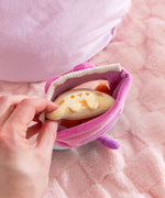 Model pulls out one light yellow tortilla chip plush from the Pusheen plush bag. The bag has a velcro closure at the top to keep the chips inside.