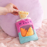Model holds one of the chip inspired plush above the purple and blue plush bag that has Pusheen's face embroidered above the see-through window.
