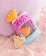 Three plush tortilla chip inspired plush sit in and around the included plush bag. Both the chips plush and bag have Pusheen the Cat's face embroidered on them.