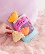 Model holds on of the light yellow triangle plush with dark yellow embroidery details. Each triangle plush features Pusheen's two triangle ears extending off the top of the plush.