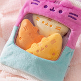Three plush tortilla chips sit inside the plush bag. The three tortilla chips are in a range of light yellow to golden yellow and feature embroidered spice dots.