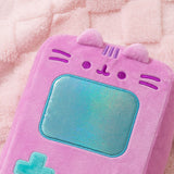 Close-up of Pusheen's face that's embroidered near the top front of the handheld plush. Pusheen's two triangle ears extend off the top front of the rectangle shaped plush. 