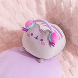 Aerial view of the gaming log plush. Pusheen's two back stripes are embroidered on her back in purple.