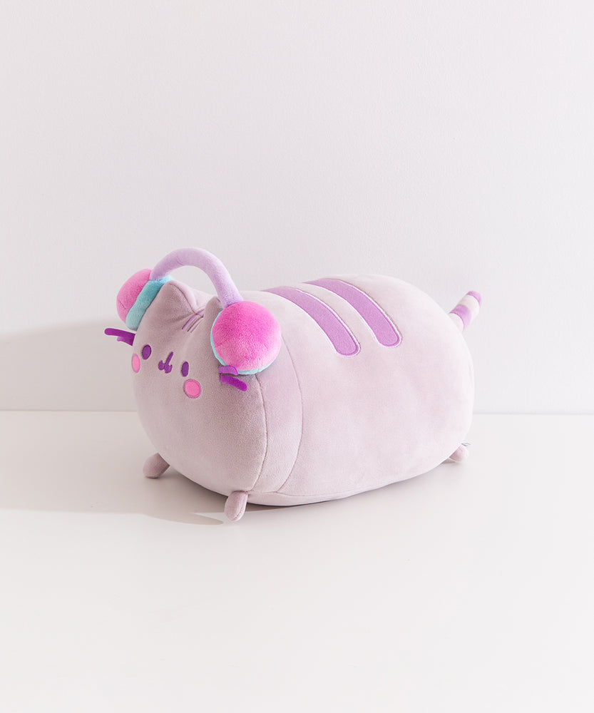 Side view of the long chunky cat plush. The rotund plush features a cat lying down with her four paws extending off the front and back.