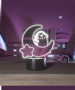 Decorative night light with Pusheen on a crescent moon with a star, placed on a wooden surface.